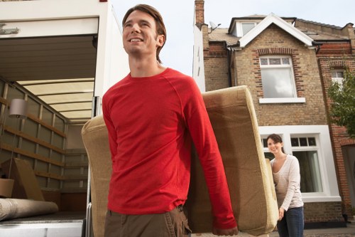 Movers carrying furniture through a period property hallway in Hampstead